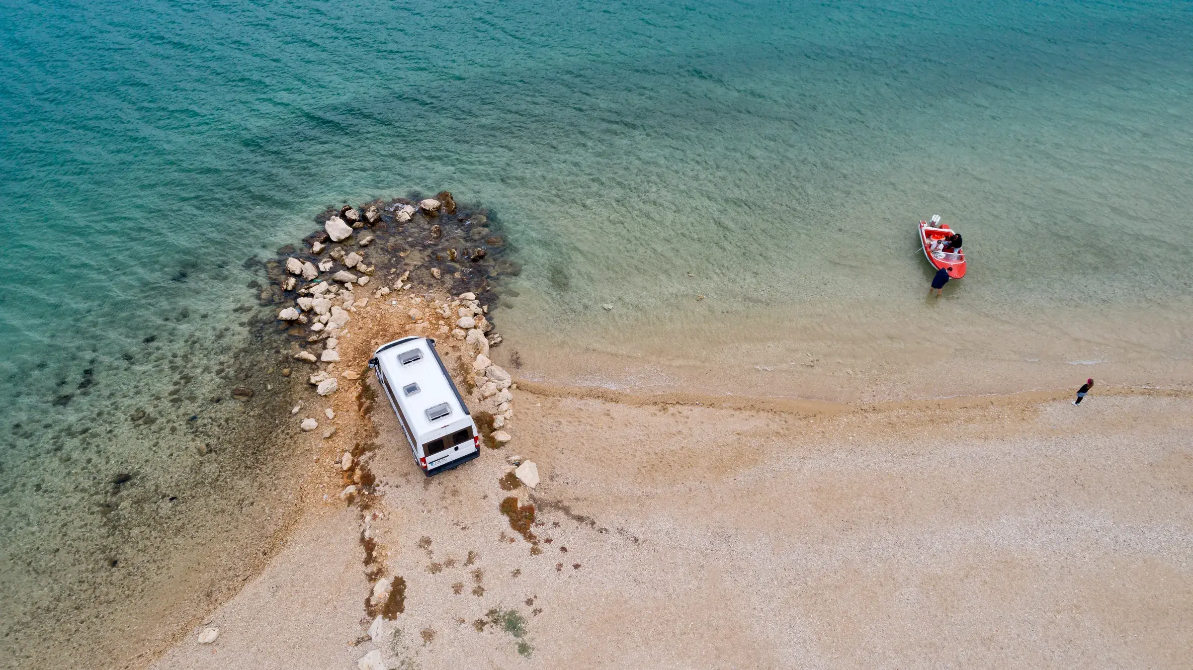 Dronefoto av Tourne på en steinstrand ved turkist vann